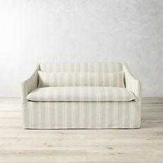 a white couch sitting on top of a hard wood floor