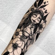 a woman with long hair and flowers on her arm is depicted in this tattoo design