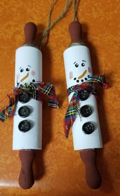 two toilet paper roll snowmen with buttons on them