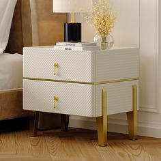 a white and gold nightstand with flowers on it next to a bed in a room