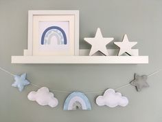 there are stars and clouds hanging on the wall next to a shelf with a picture