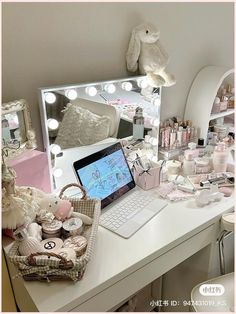 a white desk topped with a laptop computer next to a mirror covered in lights and other items