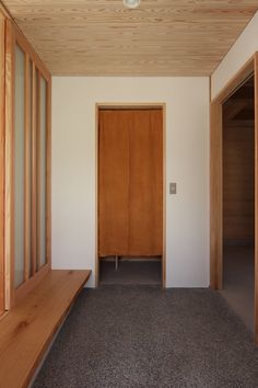 an empty hallway with wood paneling and wooden doors on either side of the room