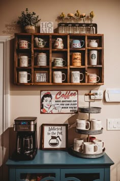 a shelf with coffee mugs on it next to a blue cabinet filled with cups