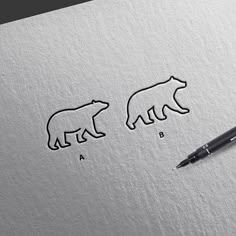 two bears are drawn on paper next to a pen