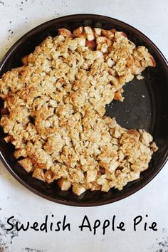 an apple pie is in a black pan on a white counter top with the words swedish apple pie above it