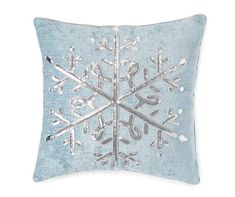 a blue pillow with snowflakes on the front and back, sitting on a white background