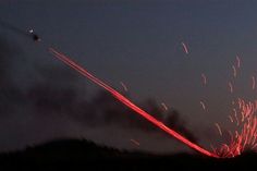 fireworks are lit up in the night sky with long exposures on them and an airplane flying overhead