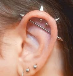 an ear piercing with three small spikes on the top and one is attached to it