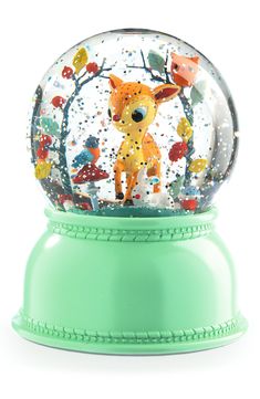 a snow globe with a deer in the middle and trees on it's side