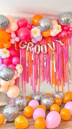 a room filled with balloons and streamers on the wall next to a sign that says love