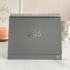 a desk calendar sitting on top of a table next to a cup and donut