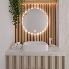 a white sink sitting under a mirror next to a wooden cabinet with plants growing on it