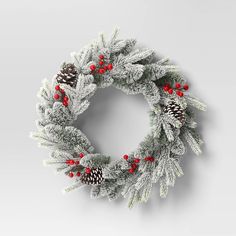 a christmas wreath with pine cones and red berries