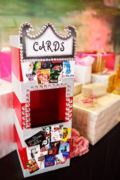 a red and white card holder sitting on top of a table next to other boxes