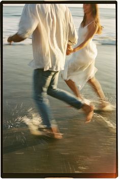 a man and woman walking on the beach