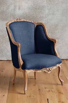 a blue chair sitting on top of a wooden floor