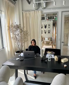 a woman sitting at a table with a laptop in front of her