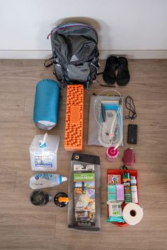 the contents of a travel bag are laid out on the floor