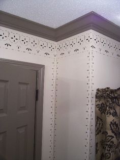 the corner of a room with an open door and decorative wallpaper on the walls