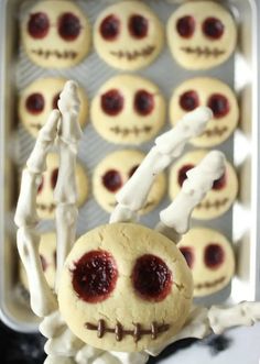 the skeleton cookie is decorated with white icing and red jelly on it's eyes