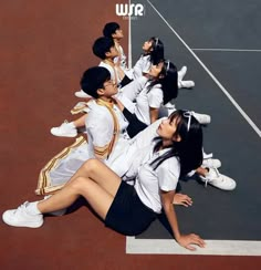 a group of people sitting on top of a tennis court holding racquets