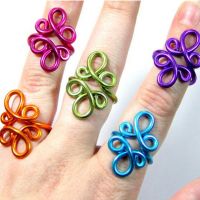 three different colored rings sitting on top of each other in someone's hand with their fingers