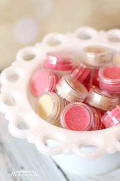 a white bowl filled with pink and yellow lip polish