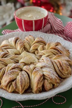 a white plate topped with pastries next to a cup of coffee and candy canes