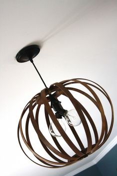 the light fixture is made out of wood strips and has two bulbs on each end