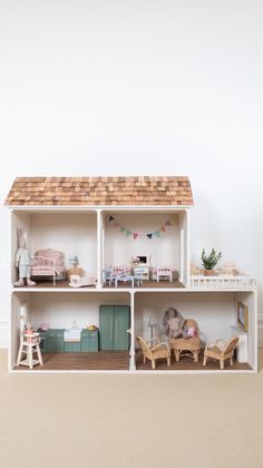 a doll house with furniture and accessories on the floor in front of a white wall