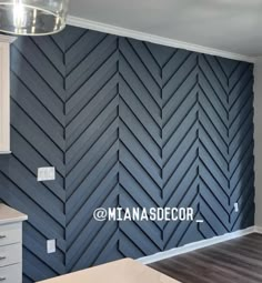 an empty kitchen with blue painted walls and white cupboards in the background, there is a large herringbone pattern on the wall