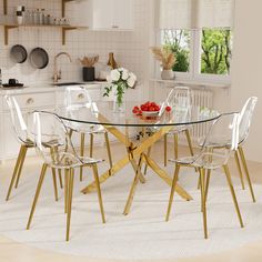 a glass table with chairs around it in a white and beige kitchen area next to an open window