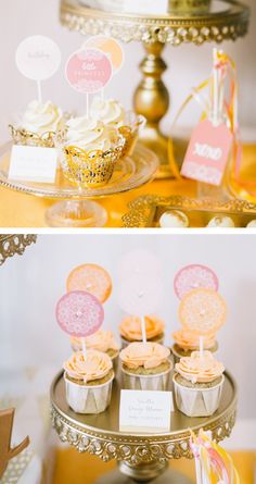 cupcakes are sitting on top of a cake stand and in front of the dessert table