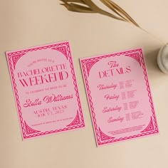 two pink and red wedding cards on a table