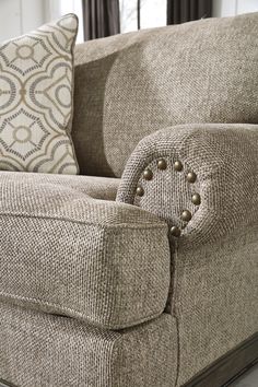 a close up of a couch with buttons on the armrests and back cushions