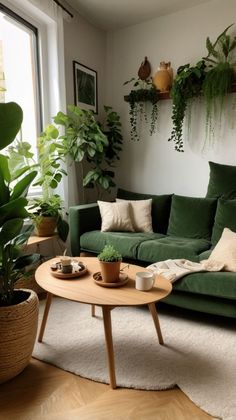 a living room with green couches and potted plants