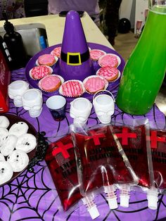 a table topped with cupcakes covered in frosting next to halloween decorations and candles