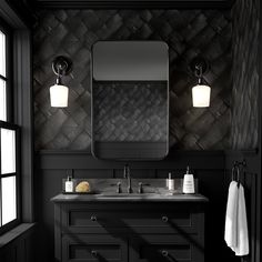 a black bathroom with two sinks and a large mirror over it's vanity area