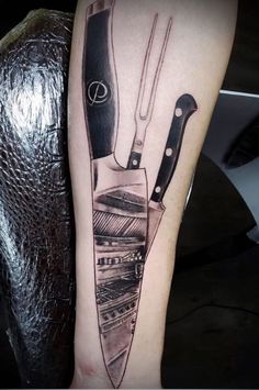 a black and white photo of a knife tattoo on the right leg, next to an arm