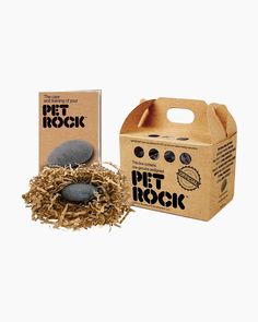 a cardboard box with some rocks in it and a package for pet rock sitting next to it