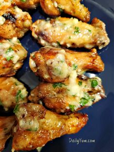 chicken wings covered in cheese and herbs on a blue plate