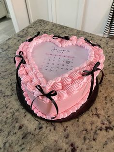 a pink heart shaped cake sitting on top of a counter