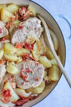 a pan filled with meat and potatoes on top of a table