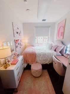 a small bedroom with a bed, desk and dresser in the corner next to a window