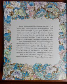 an open book with flowers and butterflies on the cover, in front of a wooden frame