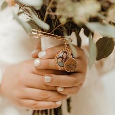 a woman holding a bouquet with flowers in her hands and a photo on the ring