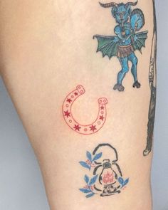 a tattoo on the leg of a woman with an image of a dragon and horseshoe