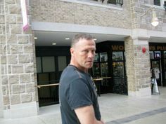 a man walking down the street in front of a building