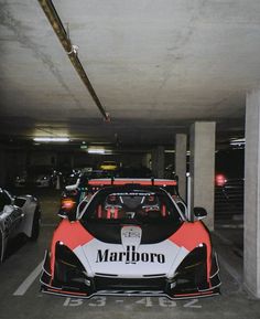 two sports cars parked in a parking garage